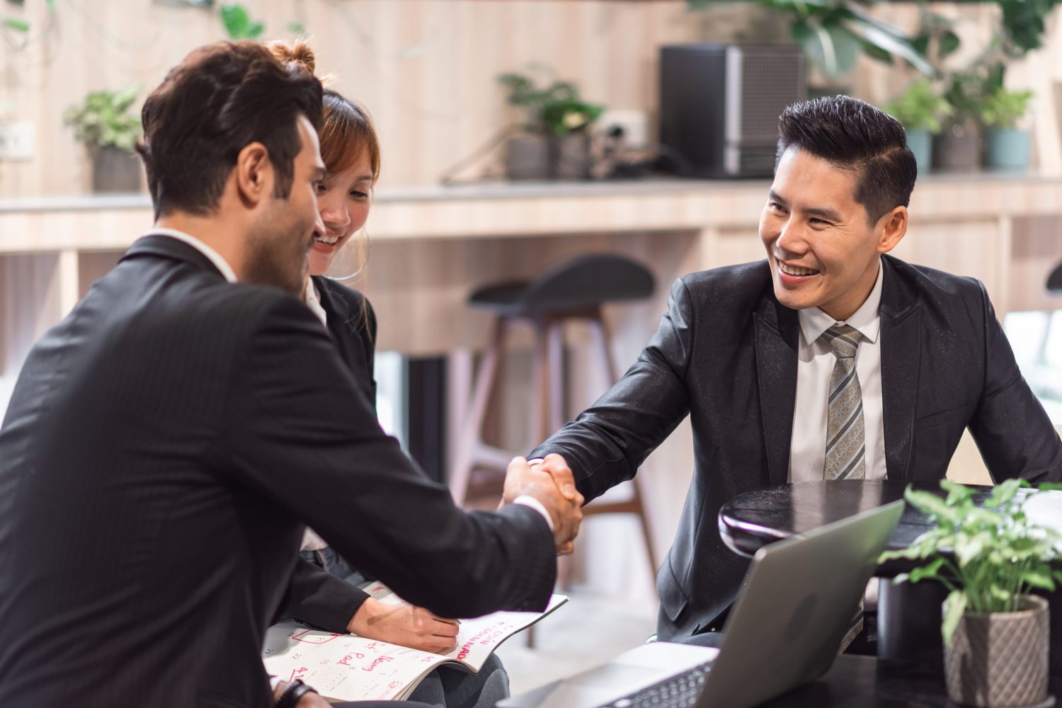 Professional consultants shaking hands with a client to symbolize a successful Singapore company incorporation.