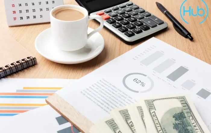 Financial planning documents, a calculator, and a desk calendar symbolizing the selection of a company's financial year end (FYE) in Singapore.